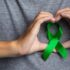 world mental health day man s hand showing heart shaped around green ribbon 1200x675 1